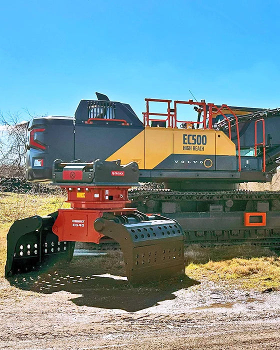 high-reach excavator in an outdoor setting with a clear blue sky and a connect work tools grapple setting on the ground near it.