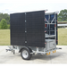 Stowed Mobile light tower with solar panels on a trailer in an outdoor setting