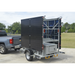 Mobile Solar Light Tower Trailer attached to a truck with a black cargo area and gray storage box on a concrete surface.