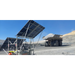 Solar panels on mobile light tower in a mining or industrial setting with a dump truck in the background.